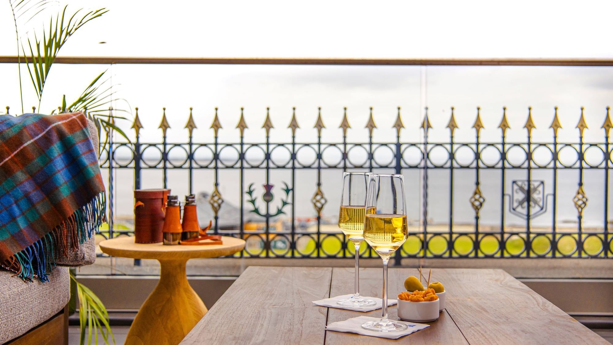 Terrace, featuring two wine glasses and a snack bowl with a plaid blanket nearby, overlooking the sea at Seaton House