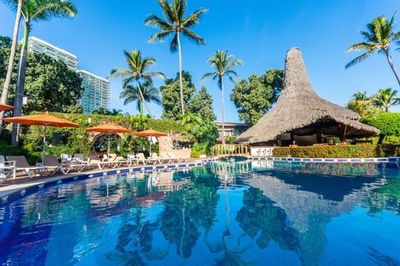 chairs and tables surrounding a hotel pool