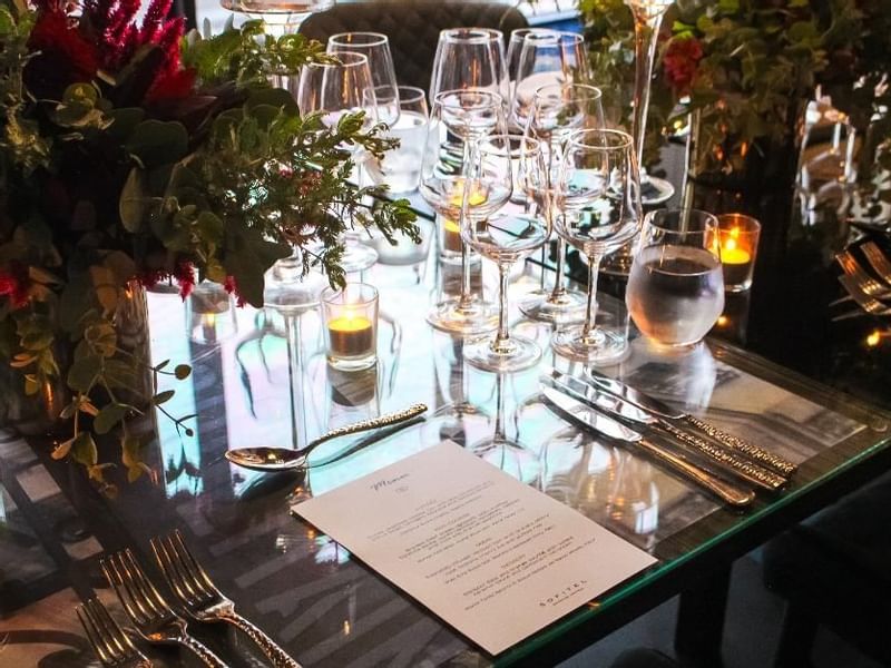 Dining table setup with candles, glassware, and a floral centerpiece in Prive at Sofitel Brisbane Central