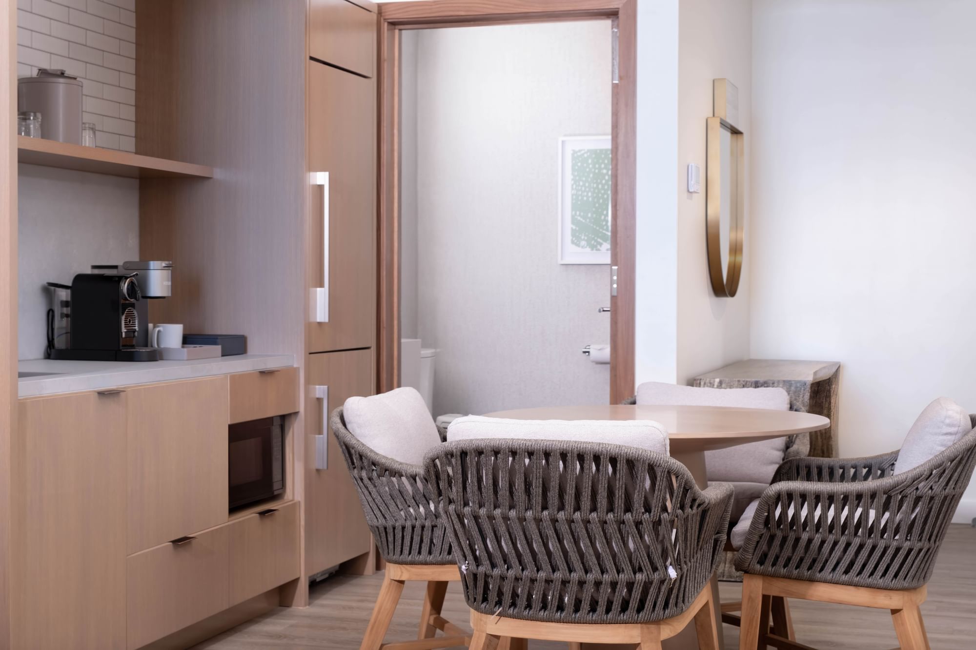 A modern kitchenette with a dining area, featuring a microwave, coffee maker, and refrigerator.