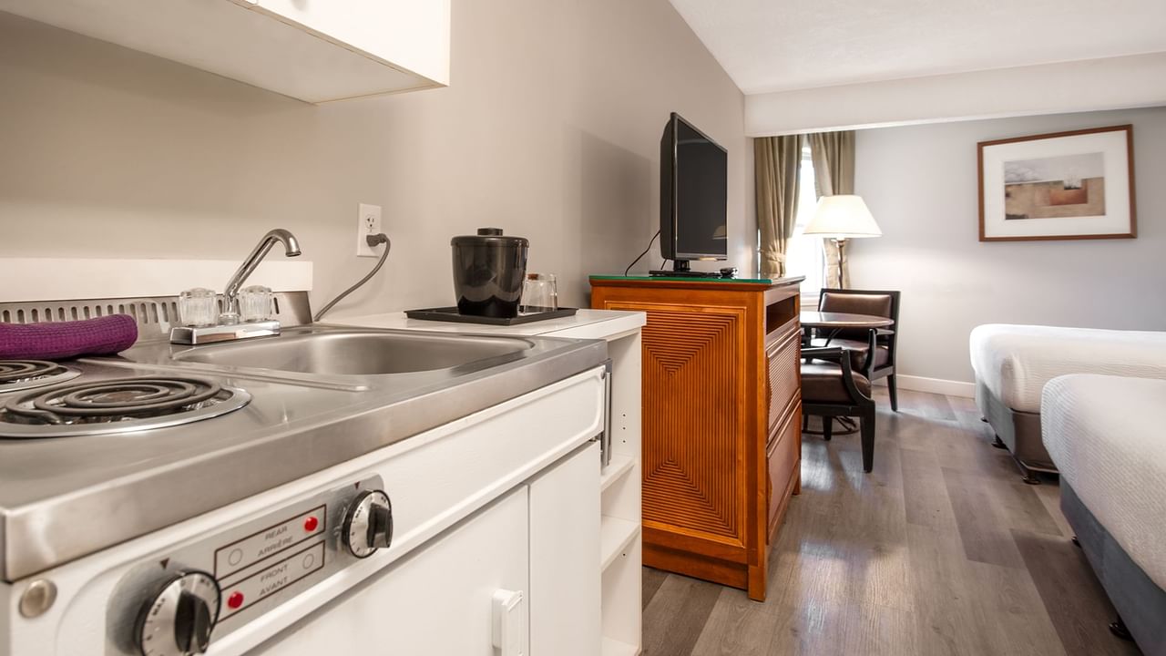 Hotel guestroom with two queen beds and a kitchenette