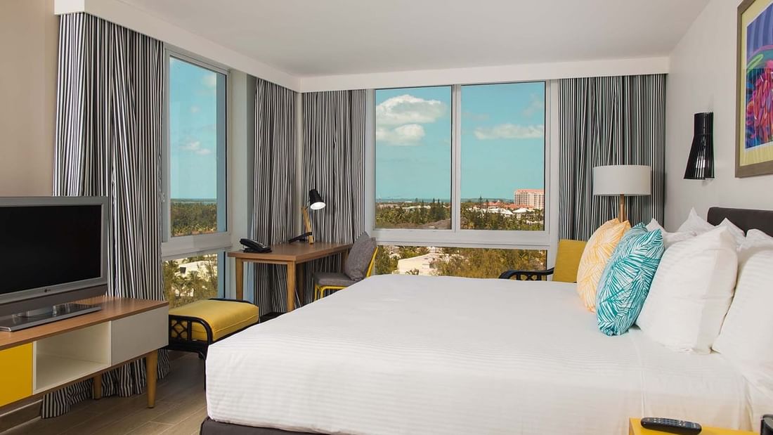 King-size bed, work desk & a TV in Water View at Warwick Paradise Island Bahamas