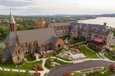 Aerial view of The Abbey Inn & Spa building, with gardens, revealing its scenic location by the water