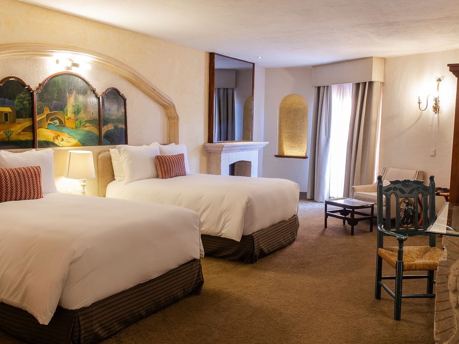King Presidential Suite with two beds, arched artwork, fireplace, and seating area at Quinta Real Zacatecas