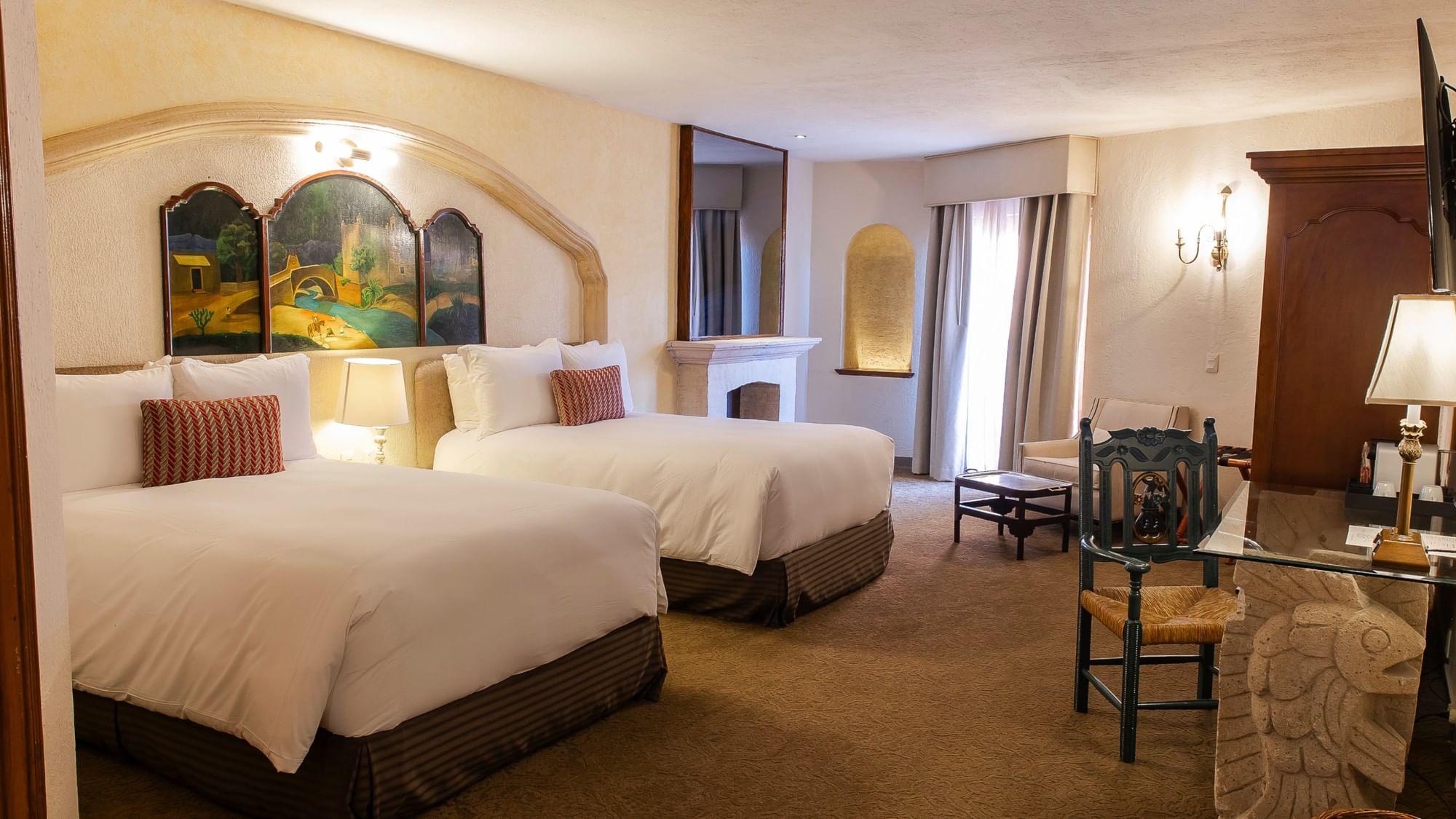 King Presidential Suite with two beds, arched artwork, fireplace, and seating area at Quinta Real Zacatecas