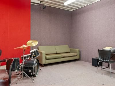 Green couch and musical instruments in a room at UniLodge Stafford House.