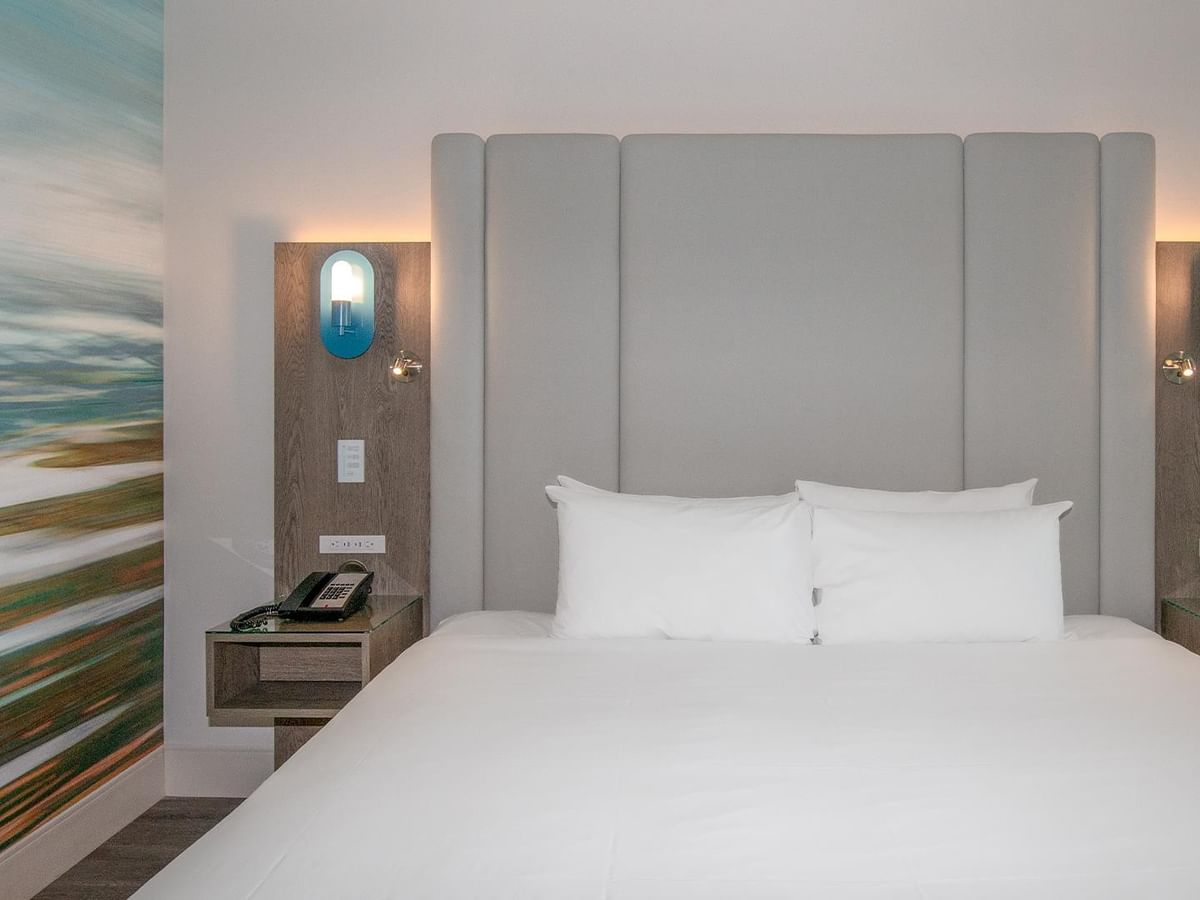 King bed with pillows and wall art.