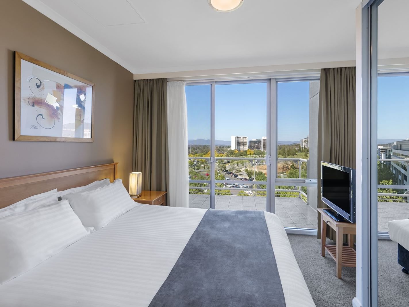 Bed & TV in 1 Bedroom with Office, city view at Nesuto Canberra