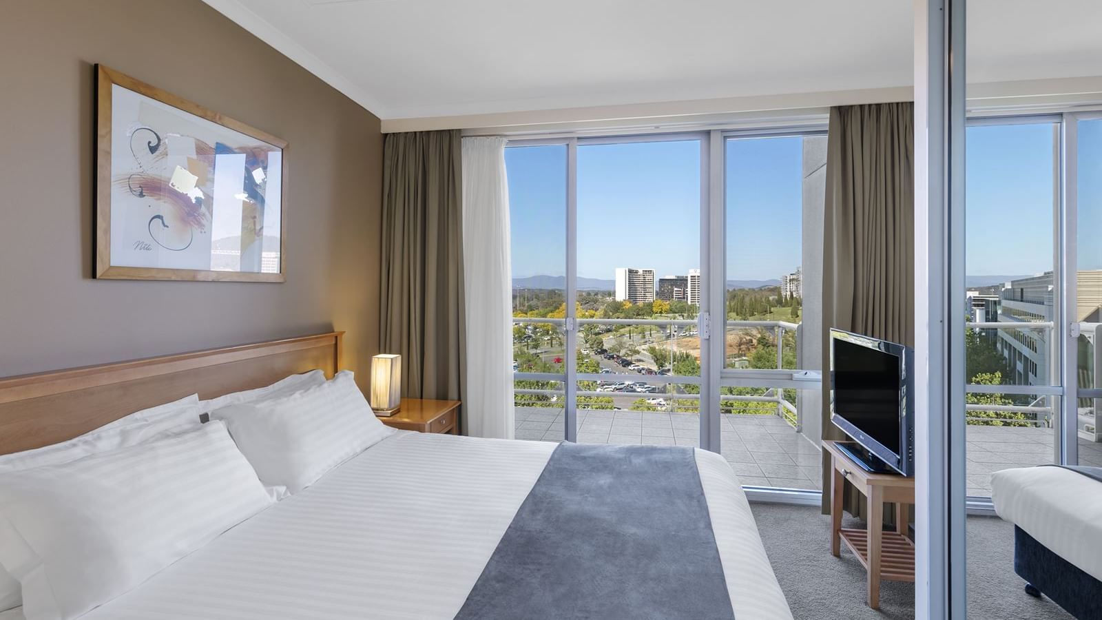Bed & TV in 1 Bedroom with Office, city view at Nesuto Canberra