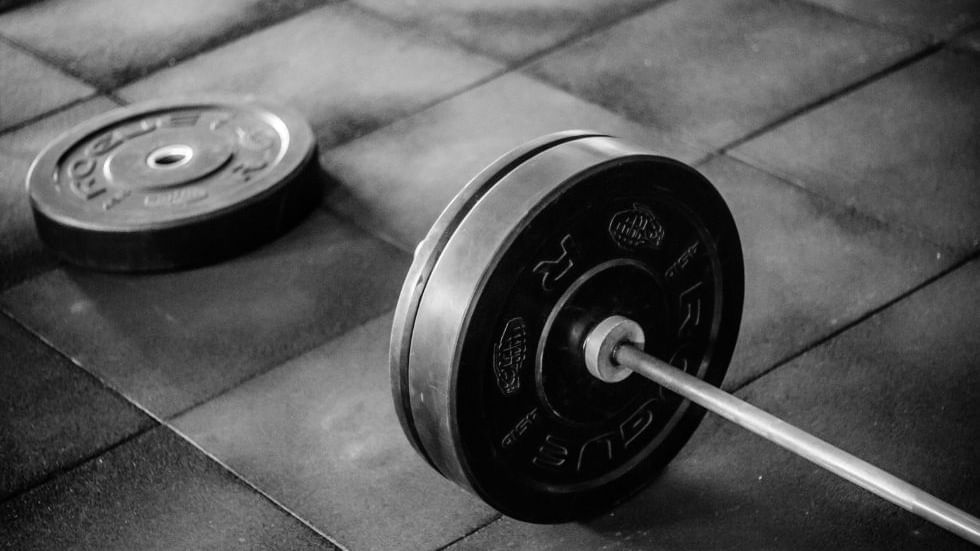 A black and white photo of a barbell with weights on a gym floor at Sunway Hotel Big Box