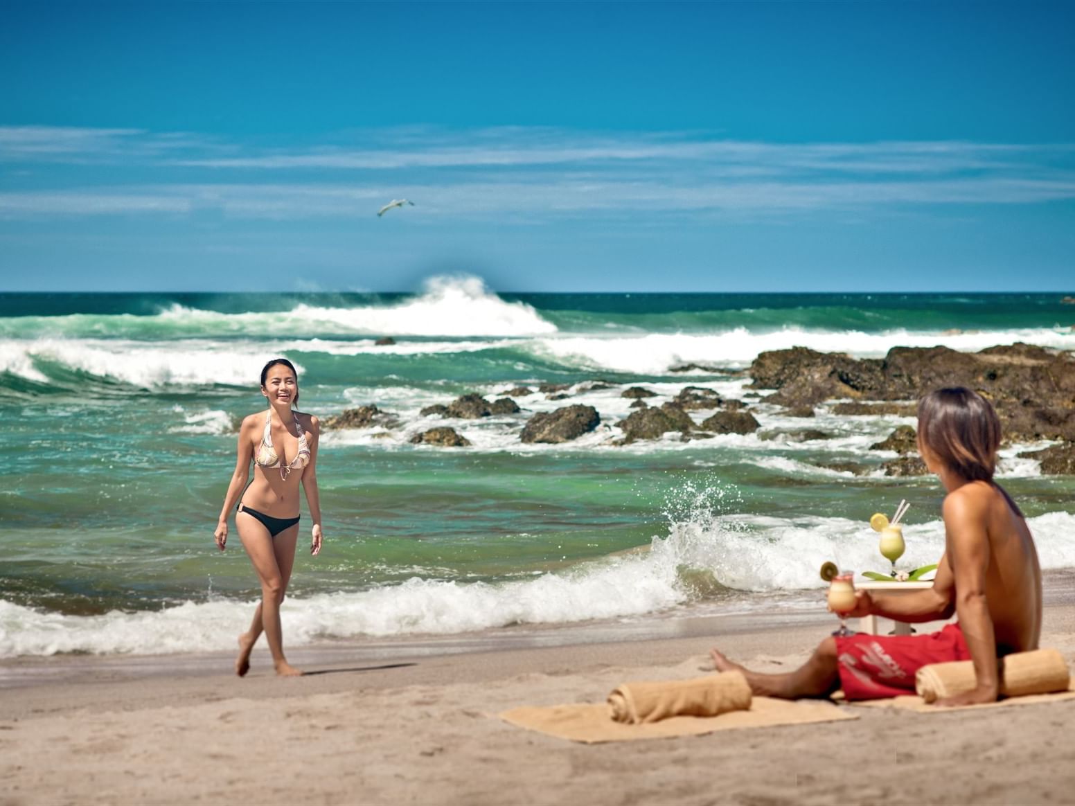 A couple sun bathing on the beach at Cala Luna Boutique Hotel
