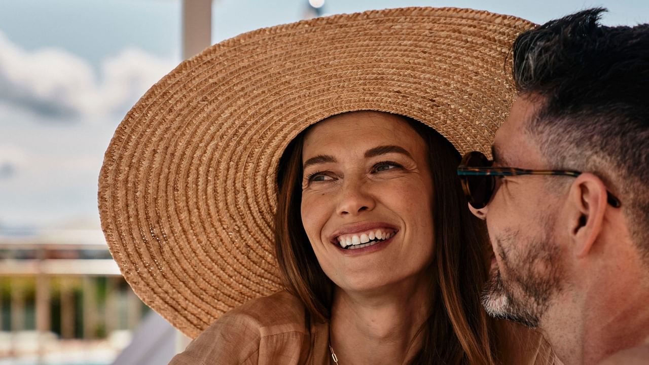 Close-up of woman wearing a hat & laughing with someone at Falkensteiner Hotel & Spa Carinzia