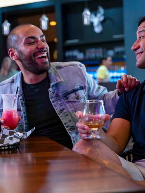 Men laughing at the table while enjoying their drinks at Cove Pocono Resorts