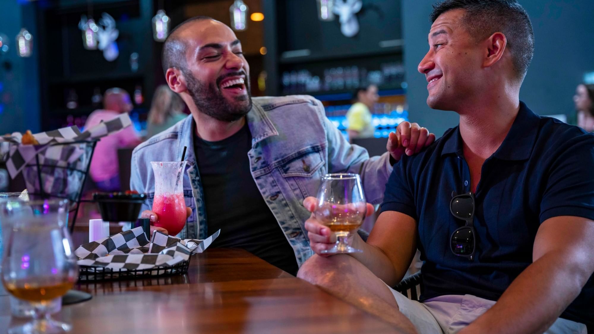 Men laughing at the table while enjoying their drinks at Cove Pocono Resorts