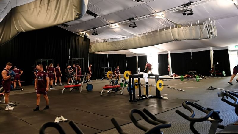 Wandiny room with athletes in maroon outfits using weightlifting equipment at Novotel Sunshine Coast Resort