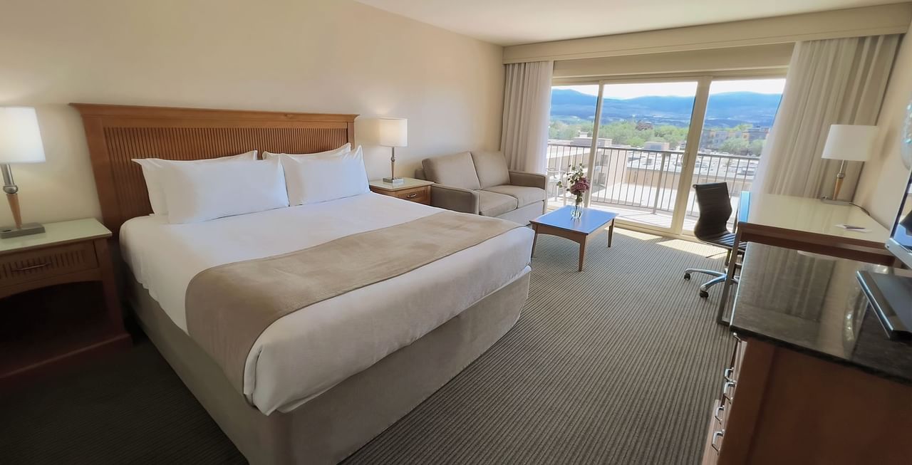 Hotel room with King bed, sofa bed, work desk, balcony, and coffee table