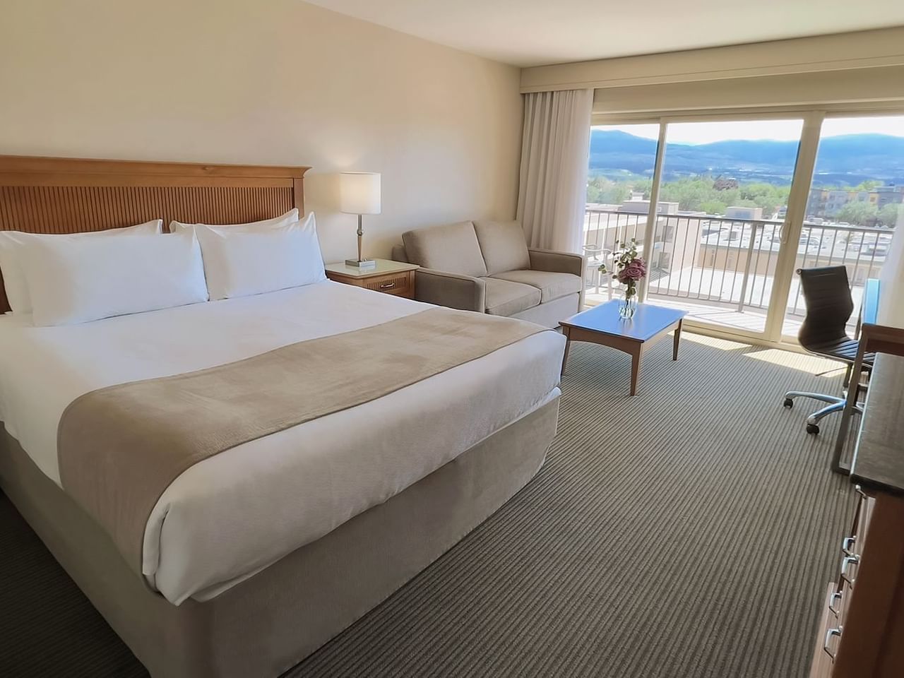 Hotel room with King bed, sofa bed, work desk, balcony, and coffee table