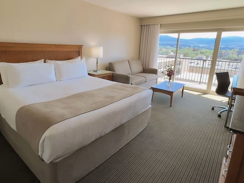 Hotel room with King bed, sofa bed, work desk, balcony, and coffee table