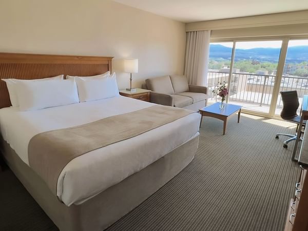 Guest room with king bed, balcony, sofa bed, table, desk, chair