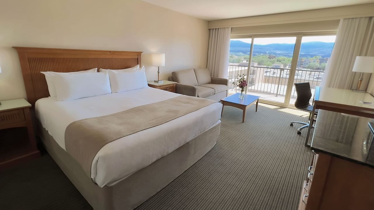 Guest room with king bed, balcony, sofa bed, table, desk, chair