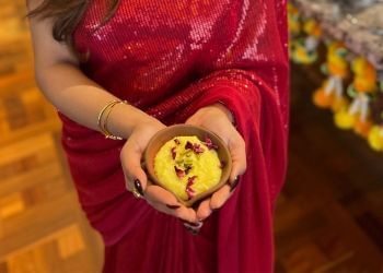 A woman in a red sari holding a bowl of Pistachio Kheer at Amora Hotel Jamison Sydney
