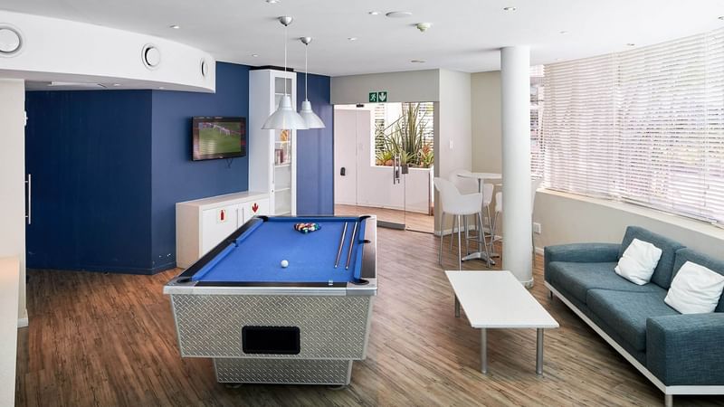 Pool table with ques in the Game room at First Breakers Resort