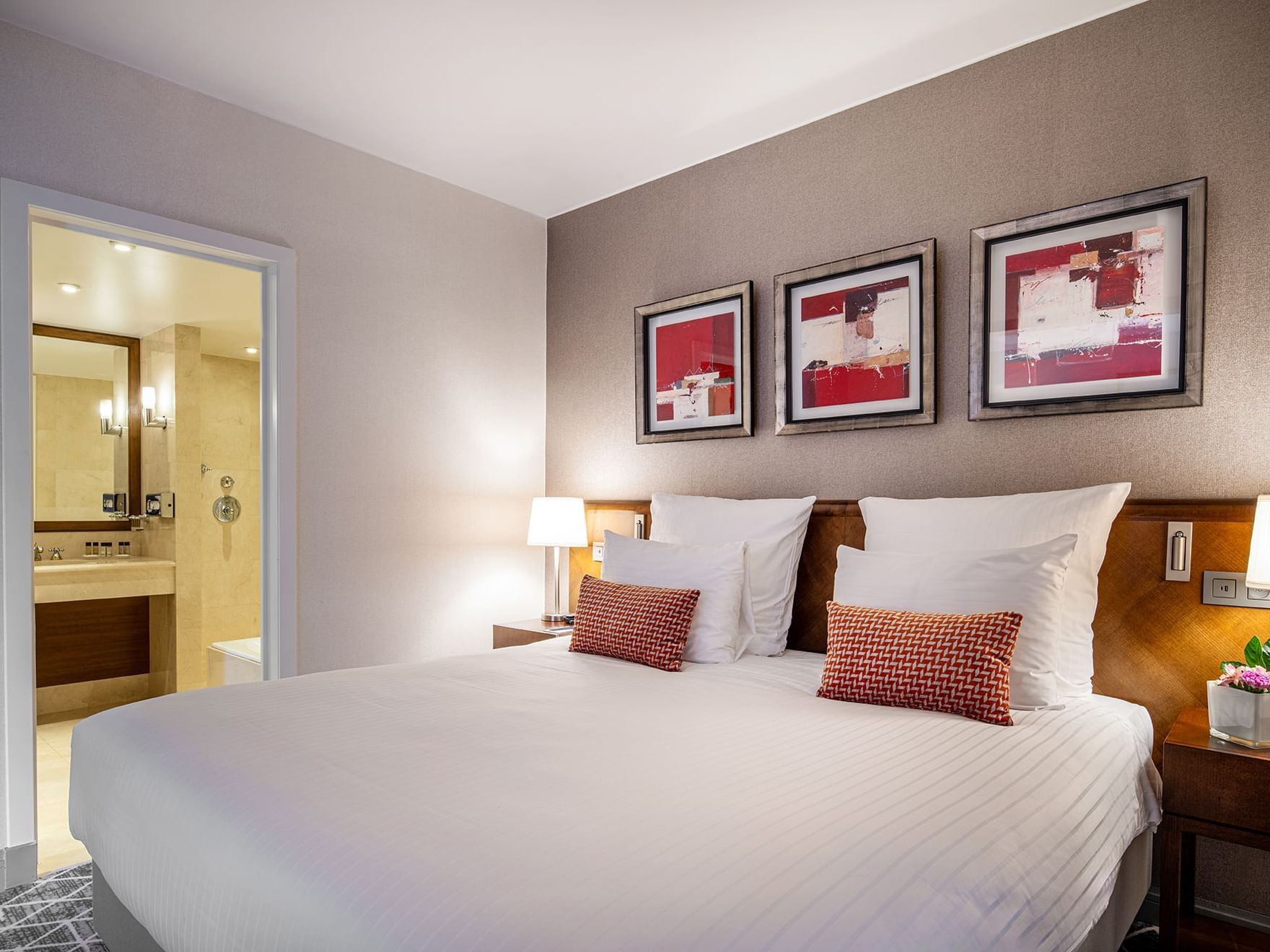 Bed with nightstand and vanity area in Junior suite at Warwick Brussels 