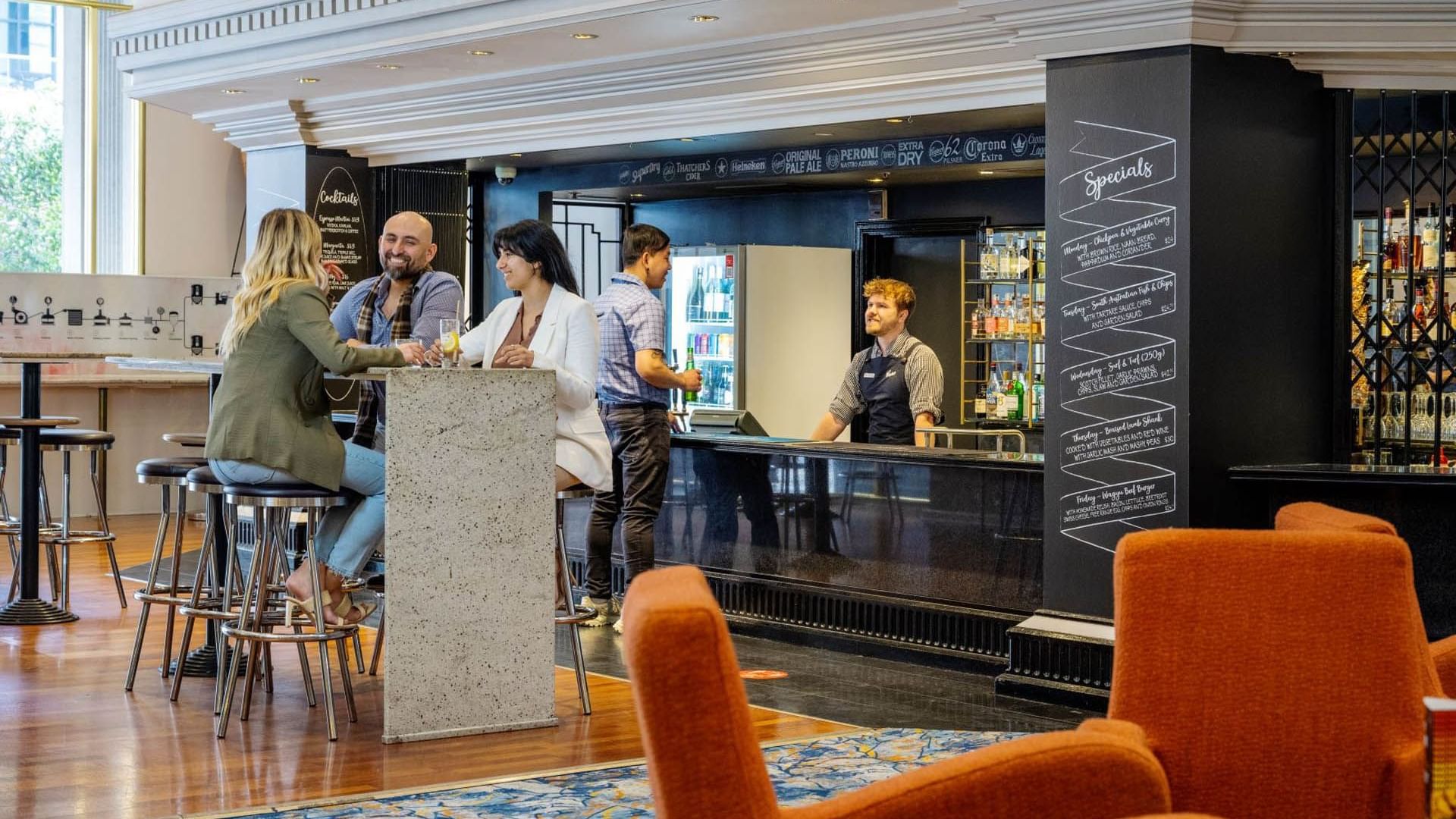People dining & lounging in Sebastyans Bar with modern interior at Grand Chancellor Adelaide