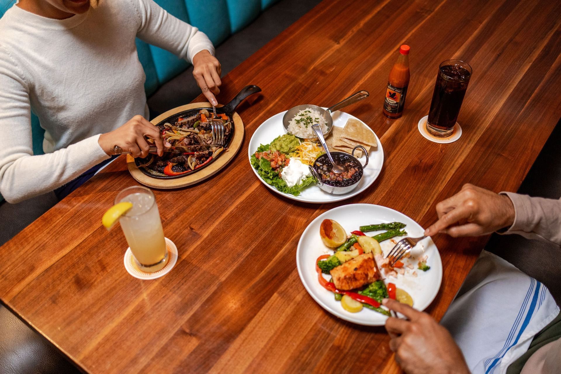 a table with food and drinks and people eating