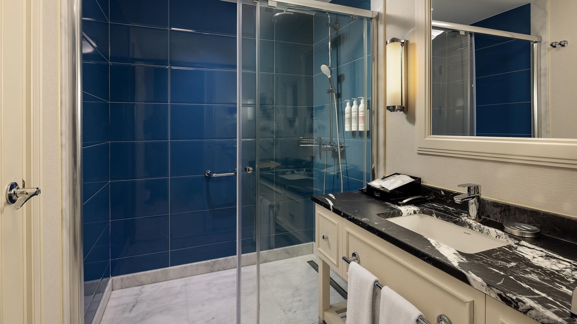 Modern blue tiled shower and sink area in a Corner Suite at Titanic Deluxe Golf Belek, Antalya.