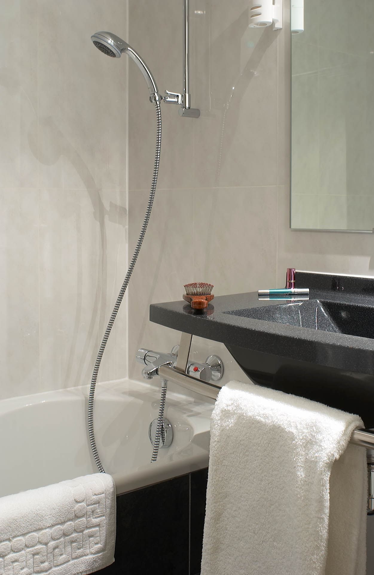 Salle de bain avec douche, miroir et lavabo à l'Escale Oceania Pornichet