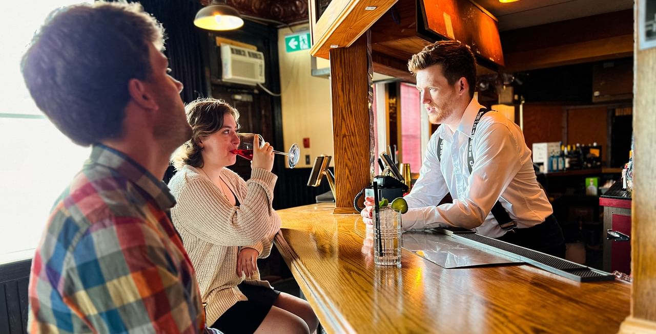 Bartender talking to customers in Gallery Restaurant at Midnight Sun, a Coast Hotel