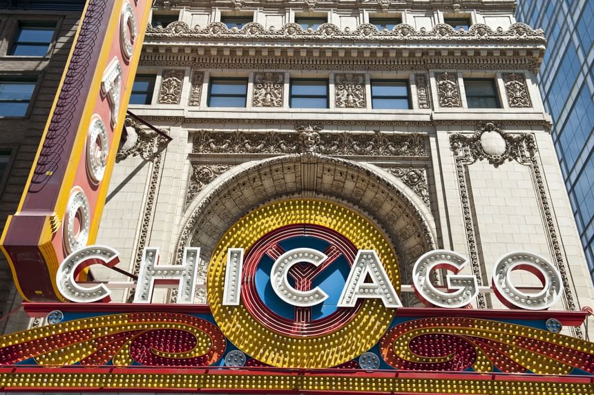 Entrance of the Chicago Theatre with illuminated marquee by ornate stone architecture near Hotel Saint Clair