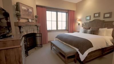 TV with fireplace facing the bed by the window in the Governor's Suite at Hotel Park City Autograph Collection