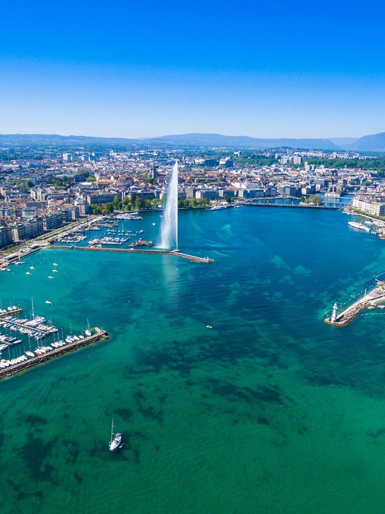 Aerial view of Geneva, featuring the Jet d'Eau fountain in Lake Geneva near Warwick Hotels & Resort on a sunny day