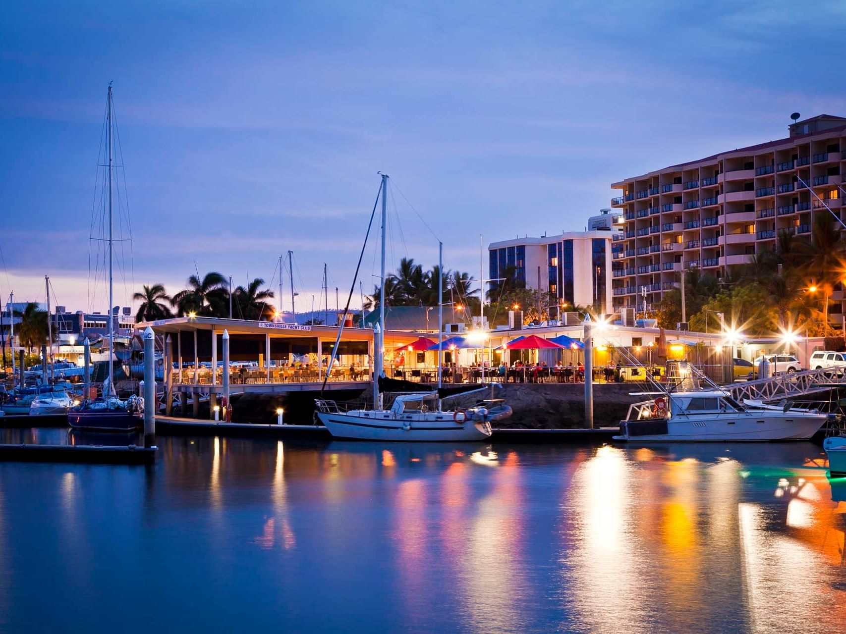 Boats stationed by the illuminated dock near Grand Chancellor Townsville