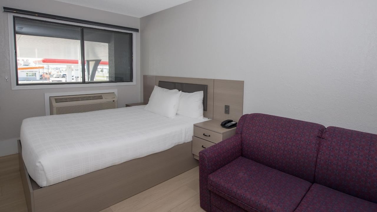 Guest room at Coast Red Deer Hotel with queen bed and sofa