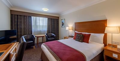 Standard Double Room with a comfortable bed, two armchairs and a TV at The Aberdeen Altens Hotel