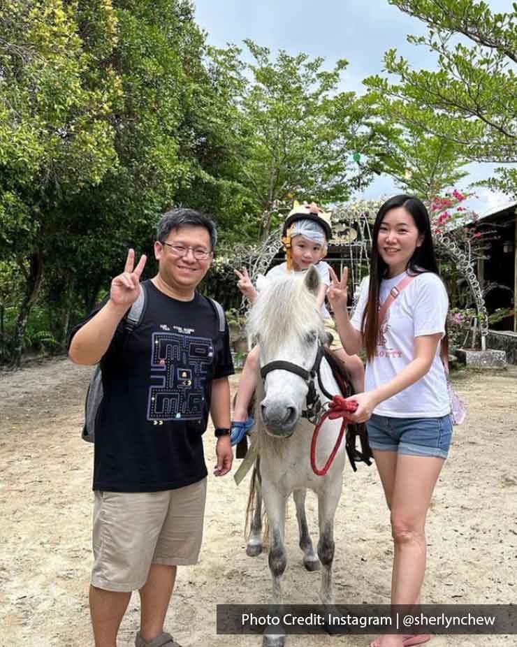 A kid was riding a horse and taking pictures with his parents at Countryside Stables - Lexis Suites Penang