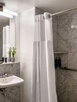 Accessible King Room bathroom featuring a vanity with a mirror and a glass shower at Warwick Allerton Chicago