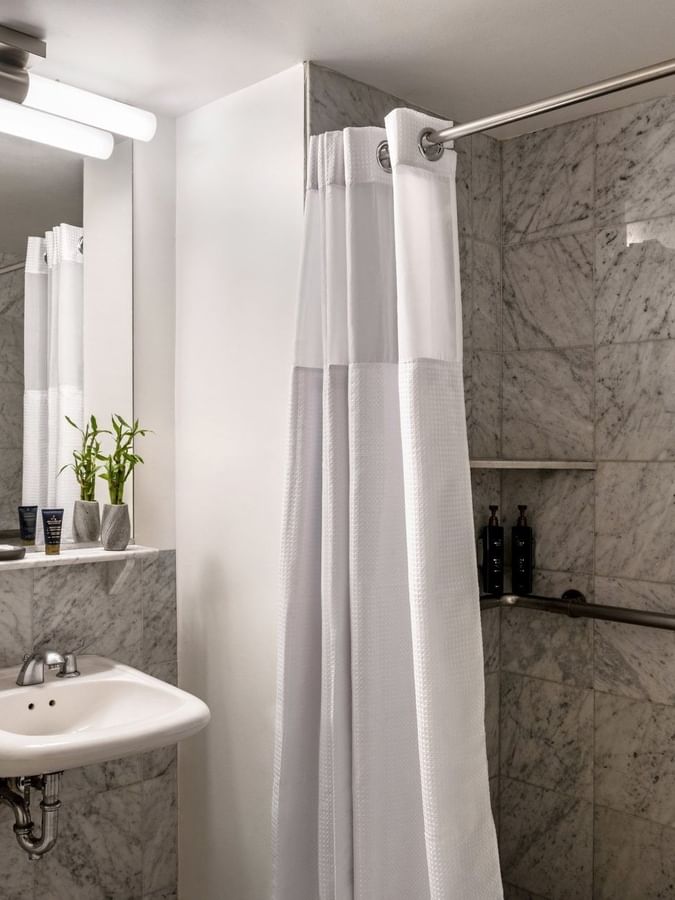Accessible King Room bathroom featuring a vanity with a mirror and a glass shower at Warwick Allerton Chicago