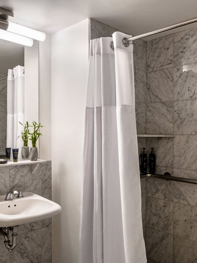 Accessible King Room bathroom featuring a vanity with a mirror and a glass shower at Warwick Allerton Chicago