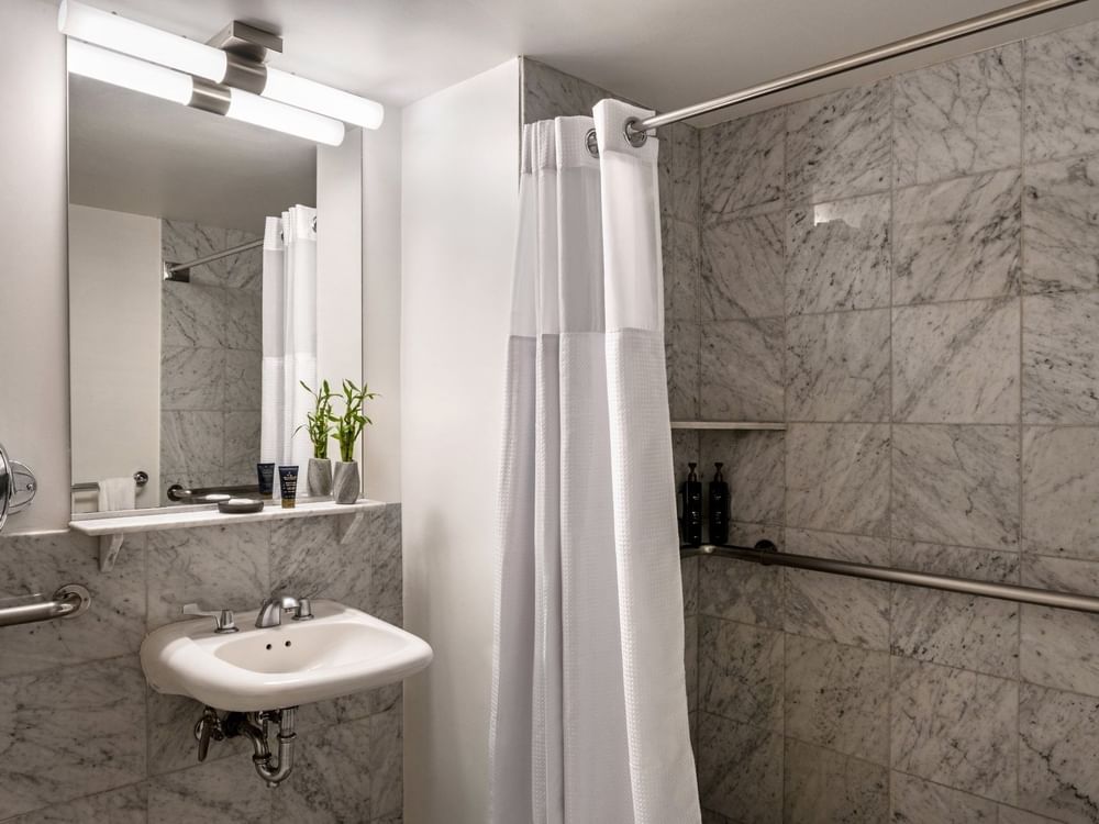 Accessible Standard Room bathroom featuring a vanity with a mirror and a glass shower at Warwick Allerton Chicago