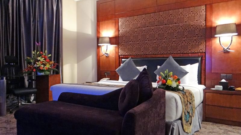 Bed with couch & nightstand in Junior Suite at Al Hamra Palace by Warwick Riyadhd