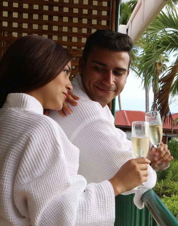 A couple having cocktails on a balcony at Copamarina Weddings