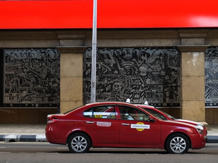 Red Malaysian Taxi outside of a building near Sunway Putra Hotel