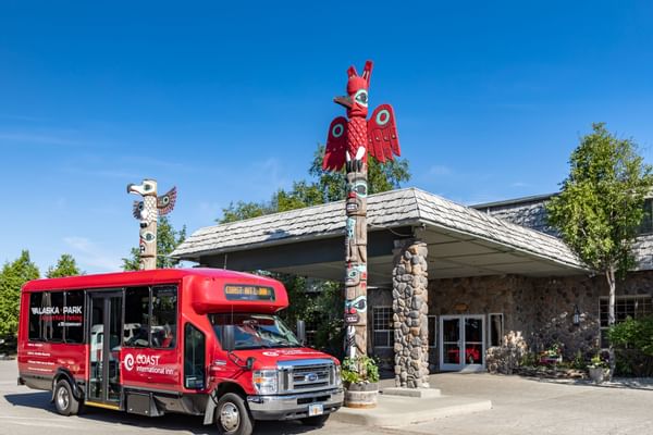 Coast Inn at Lake Hood entrance with shuttle and two totem poles