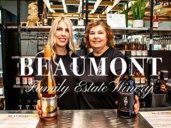 Two women at a bar with bottles of Beaumont Family Estate Winery.
