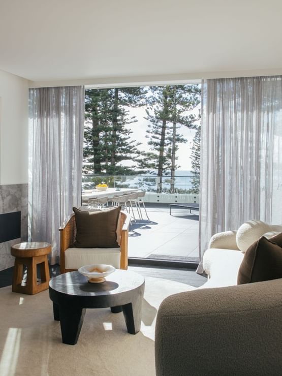 Elysium Suite at Elysium Manly with a curved sofa by a coffee table, overlooking a terrace, a featured hotel in Manly