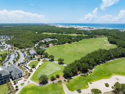 Aerial view of the Camp Creek Driving Range with lush green fairways and coastal scenery at Camp Creek Inn in Inlet Beach.